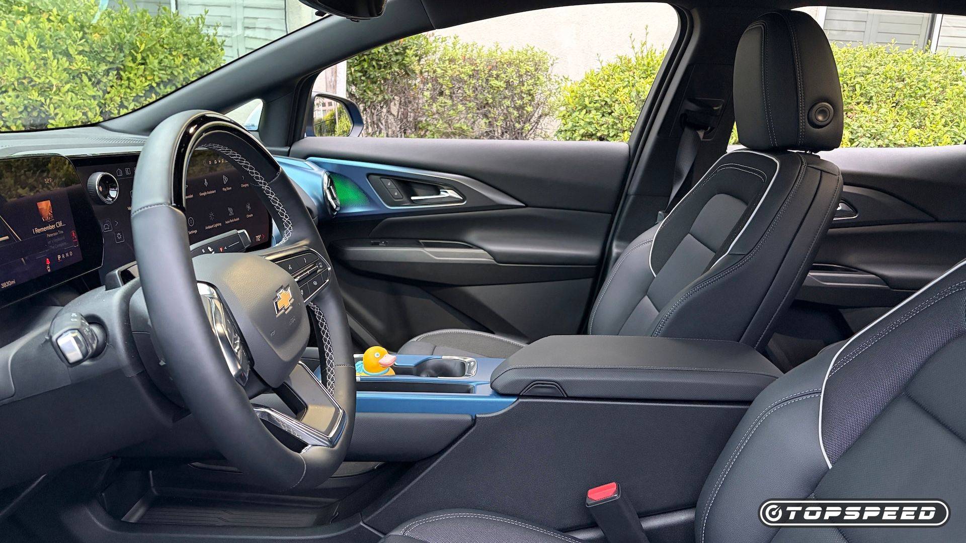 Interior of a Chevrolet Equinox EV showing the steering wheel, digital dashboard, black front seats, and center console.