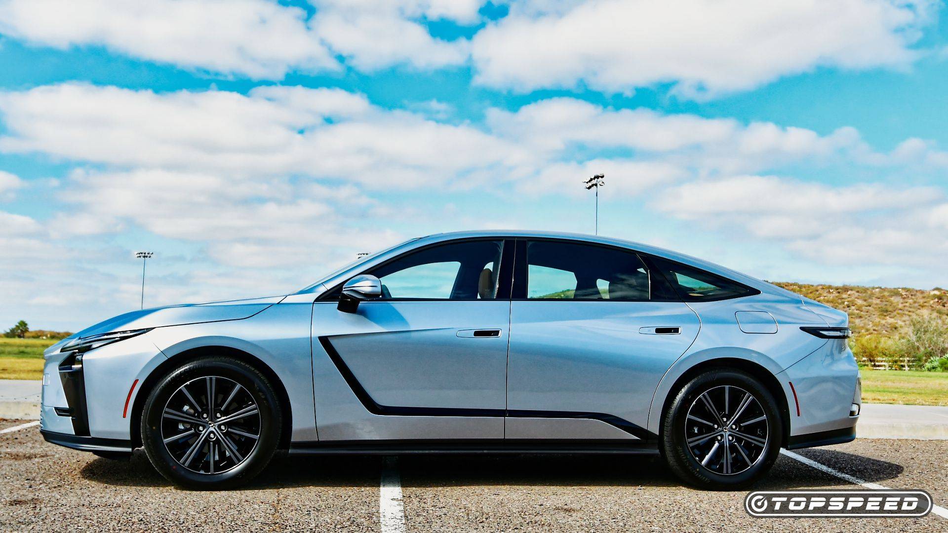 Silver Lexus ES sedan shown in side profile under a cloudy sky