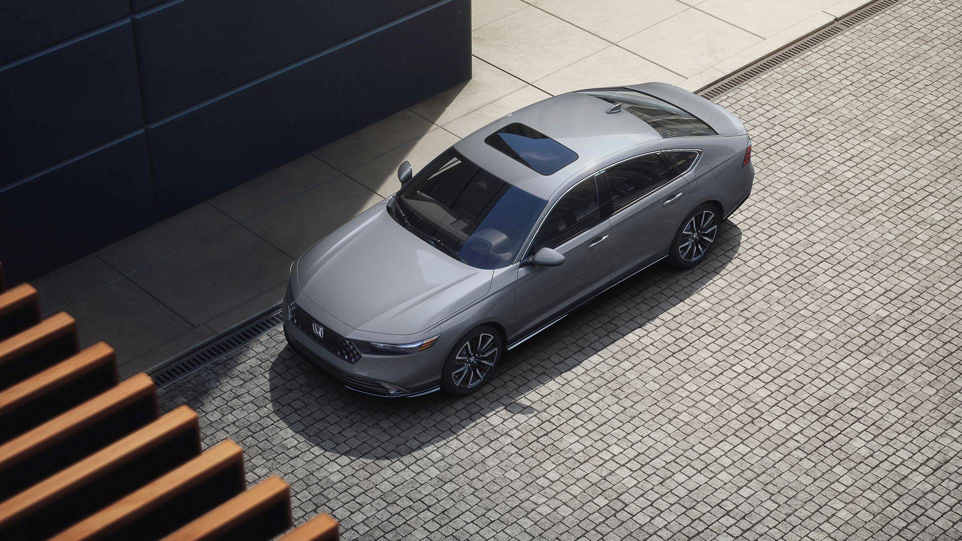 Overhead view of a silver Honda Accord sedan with a sunroof parked on a cobblestone street.