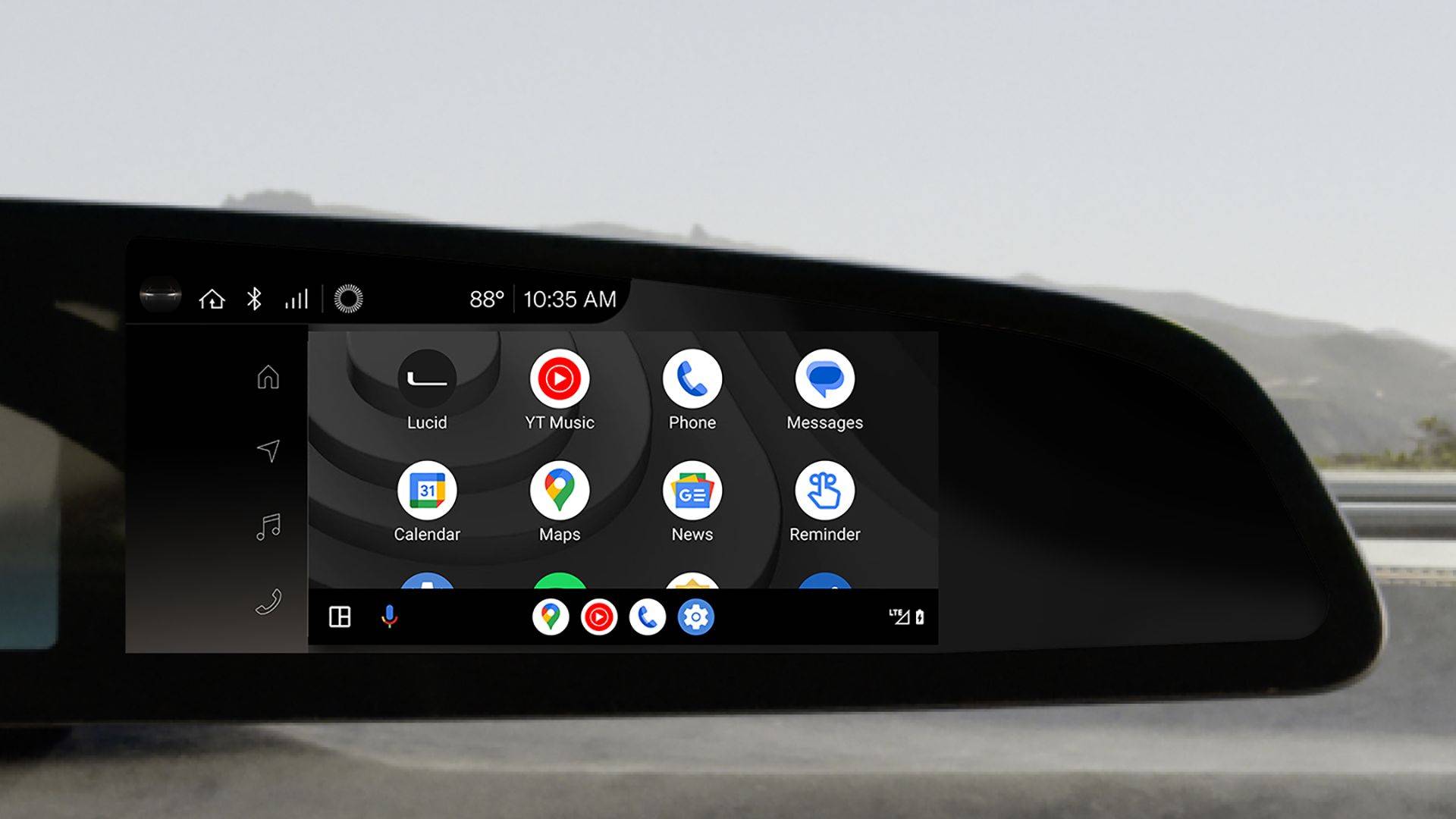 Lucid Air dashboard screen displaying Android Auto app icons including YouTube Music, Phone, Messages, Calendar, Maps, News, and Reminder.