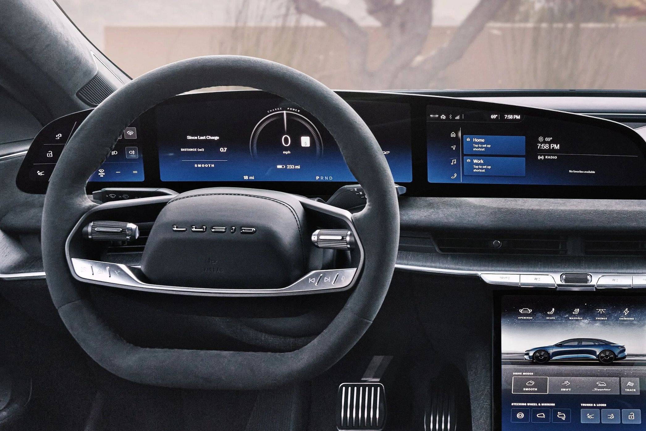 Lucid Air Sapphire interior showing the steering wheel, digital dashboard, infotainment screen, and touchscreen vehicle controls.