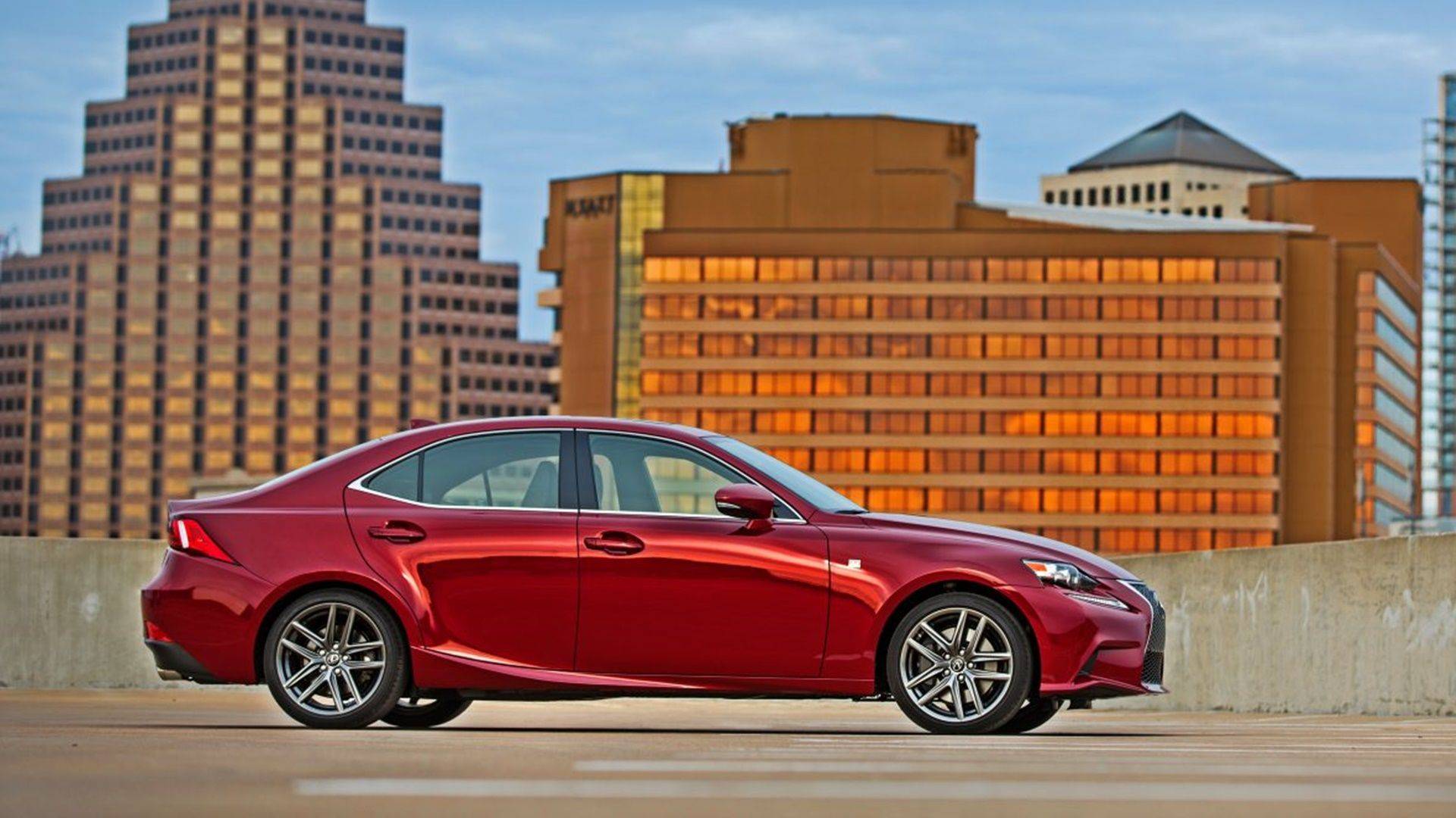 Red 2014 Lexus IS 350 rear three-quarter view on a racetrack