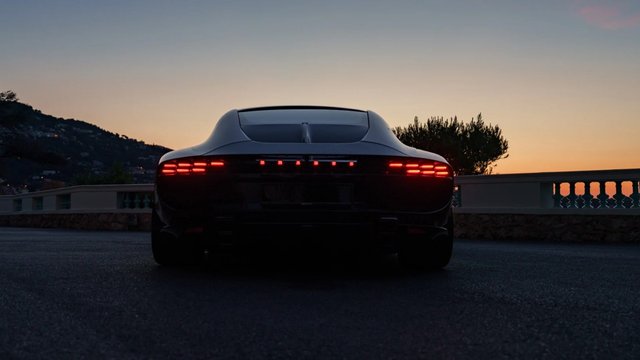 Rear view of a BRABUS BODO roadster at sunset with red LED taillights illuminated