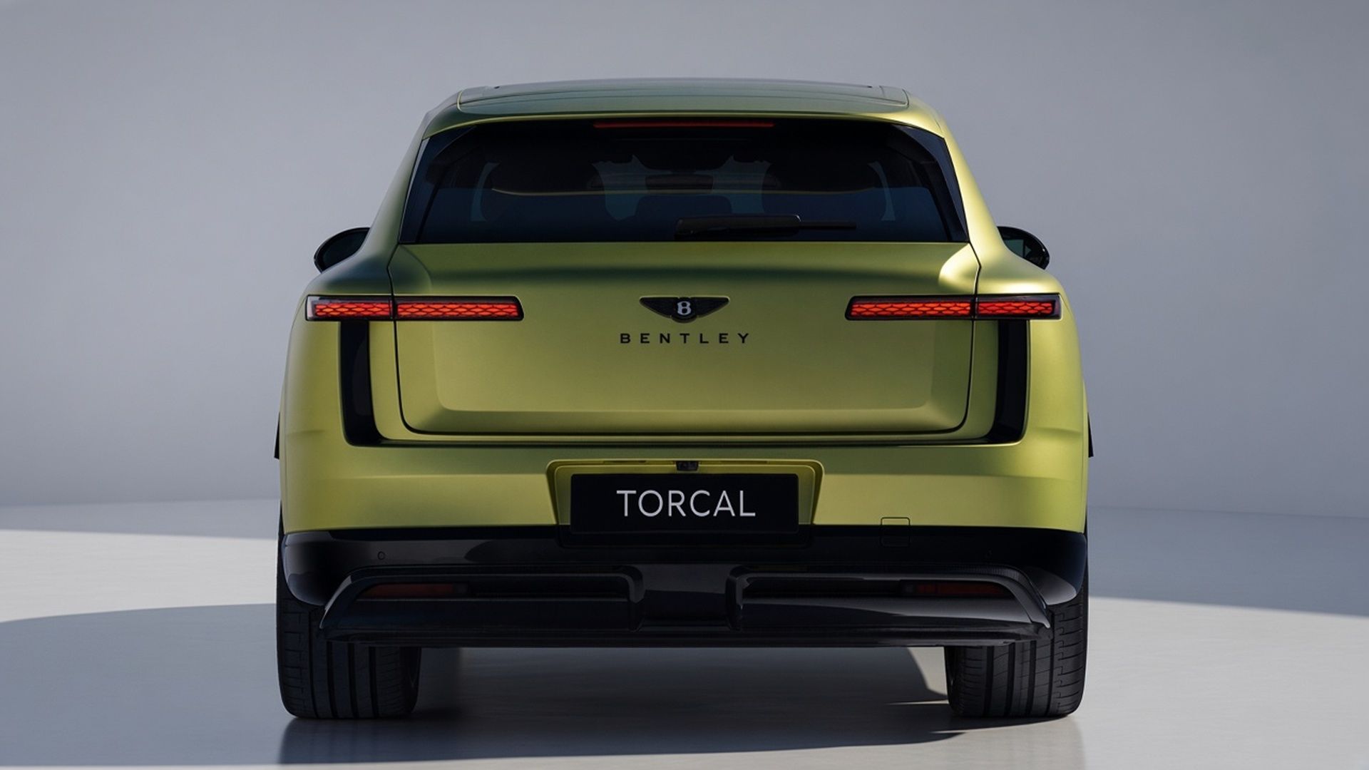 Green Bentley Torcal electric SUV viewed from the rear in a studio