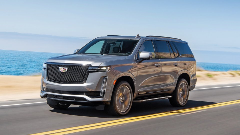 Gray Cadillac Escalade driving along a coastal highway