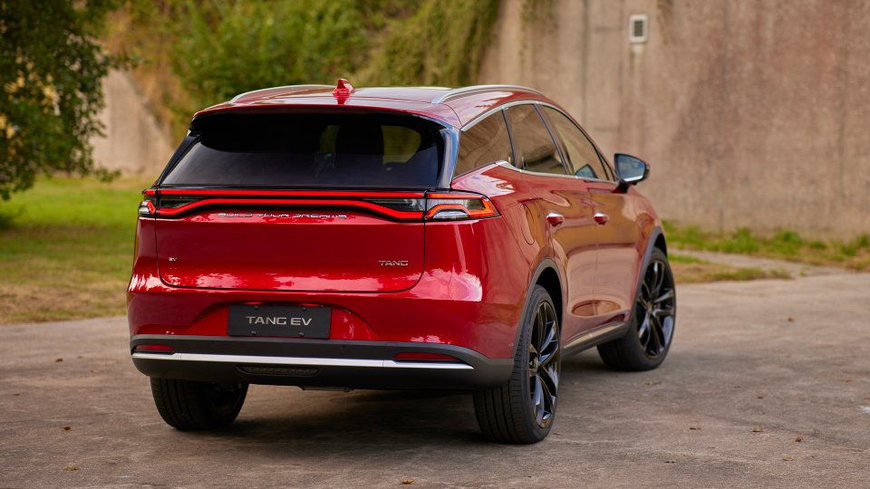 Rear view of a red BYD Tang EV with full-width LED taillight bar