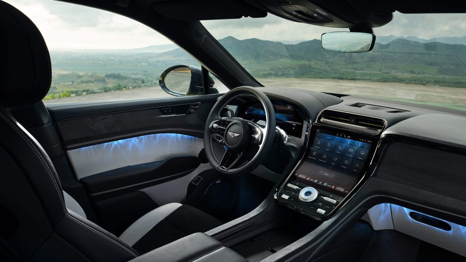 Bentley Torcal front cabin with digital displays, carbon-fiber trim, and blue ambient lighting