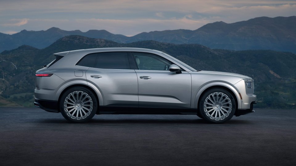 Side-profile view of a silver Bentley Torcal at a mountain overlook