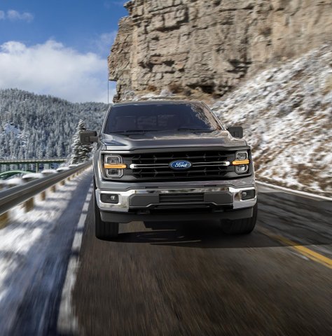 Ford F-150 driving beside a snow-dusted mountain cliff