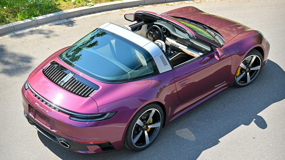 Porsche 911 Targa 4S finished in color-shifting Magic Magenta on a sunlit road