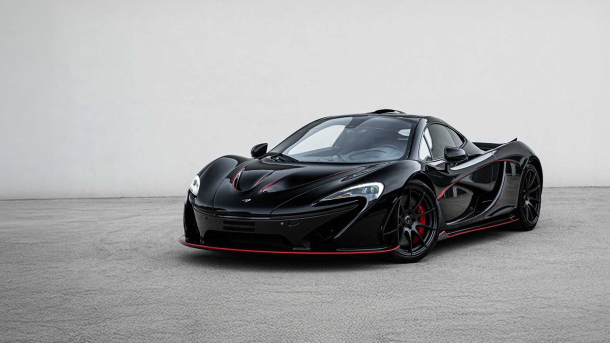 Black McLaren P1 hybrid hypercar parked in a studio-style setting