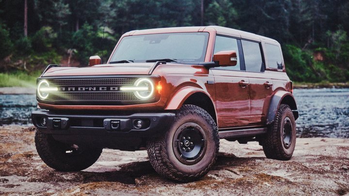 Two-tone Ford Bronco Filson with rugged tires on a rocky riverside
