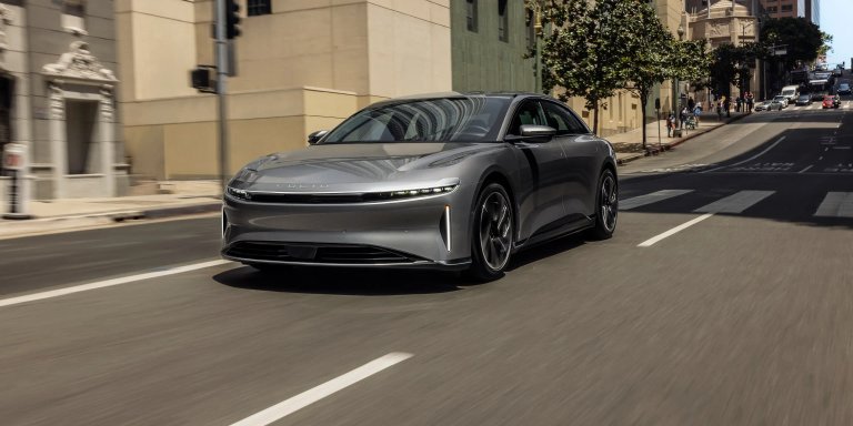 Gray Lucid Air electric sedan driving on an urban street