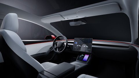 Tesla Model 3 cabin with a central touchscreen, steering wheel and minimalist dashboard