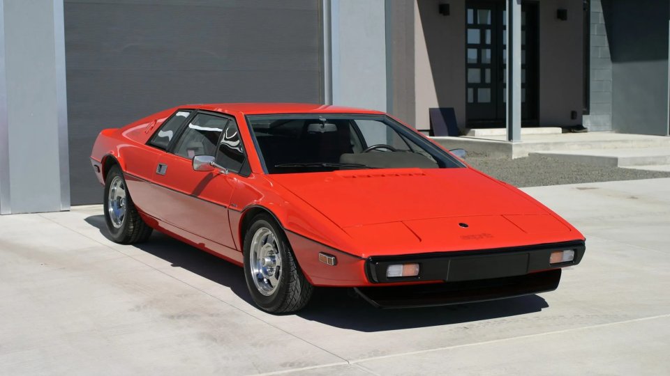 Red 1977 Lotus Esprit S1 parked outside a modern building