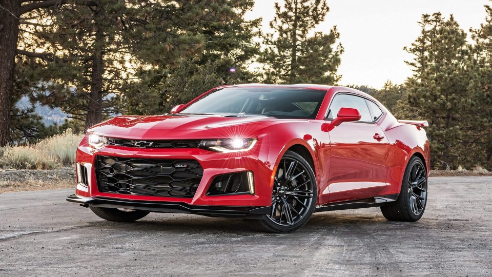 Red Chevrolet Camaro ZL1 parked beside pine trees