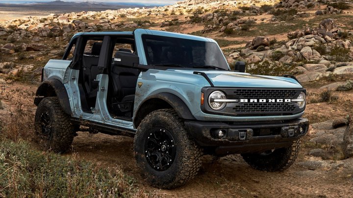 Light blue 2021 Ford Bronco four-door with removable doors on rocky terrain