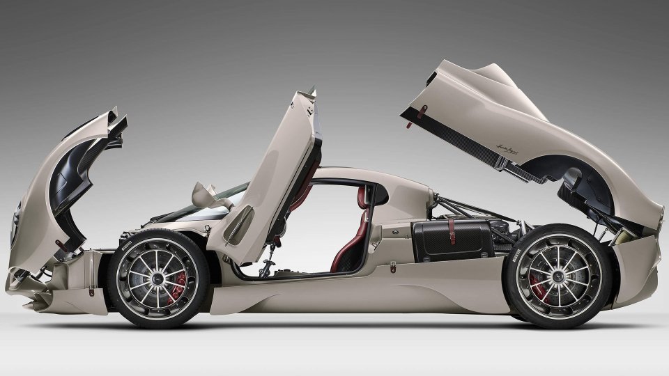 Cream Pagani Utopia with its front and rear bodywork open, revealing the carbon-fiber structure