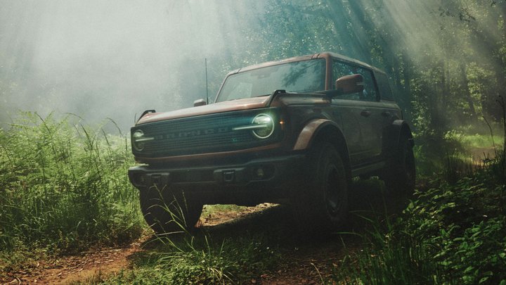 Ford Bronco Filson driving along a fern-lined forest trail