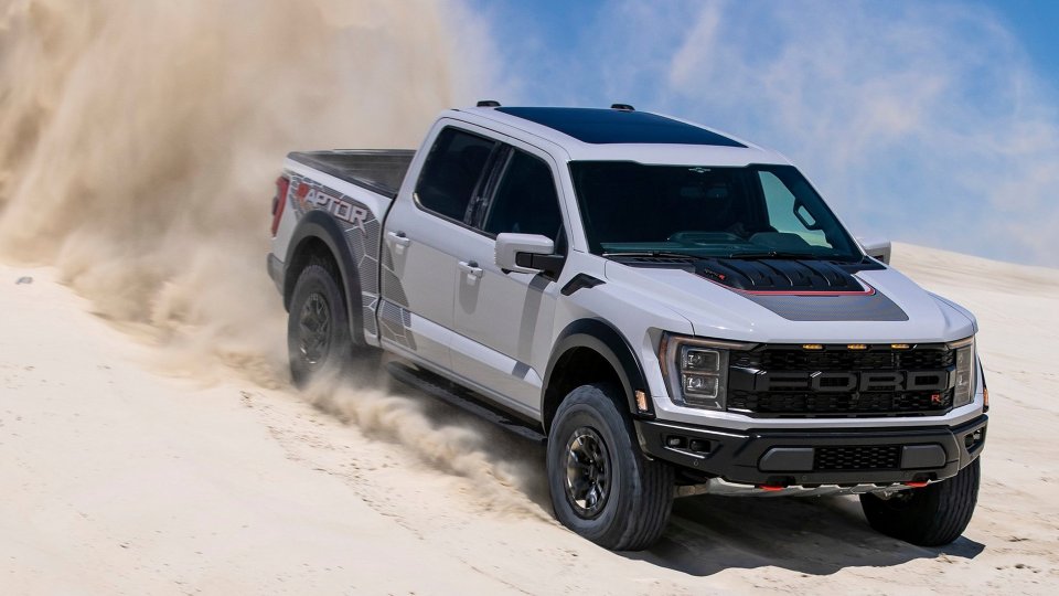 White Ford F-150 Raptor R driving through sand