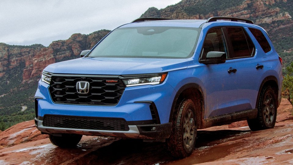 Blue Honda Pilot TrailSport on a wet rocky trail