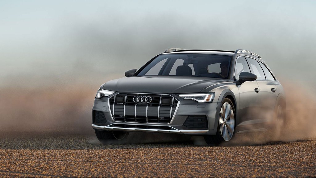 Gray Audi A6 allroad driving on a gravel road.