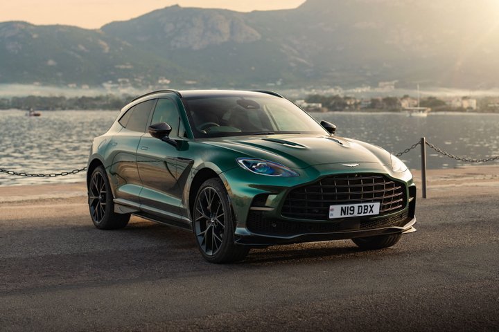 Green Aston Martin DBX707 parked beside a waterfront