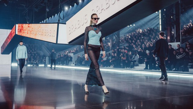 Model wearing a turquoise corset-style top during a BRABUS runway presentation