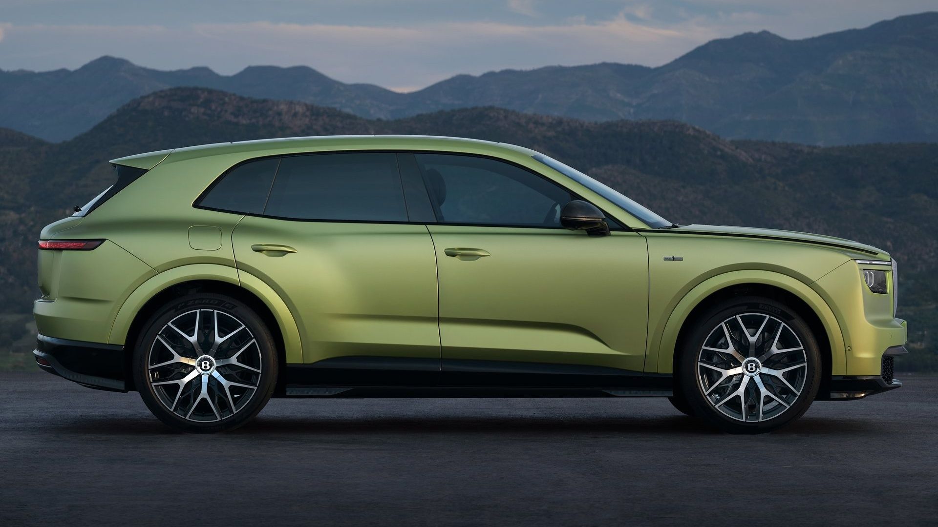 Green Bentley Torcal luxury SUV in side profile against mountain scenery