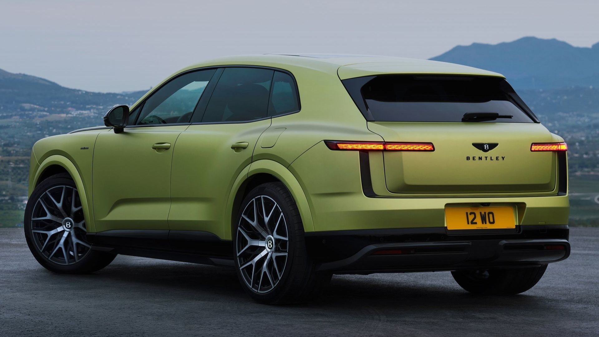 Green Bentley Torcal electric SUV in rear three-quarter view