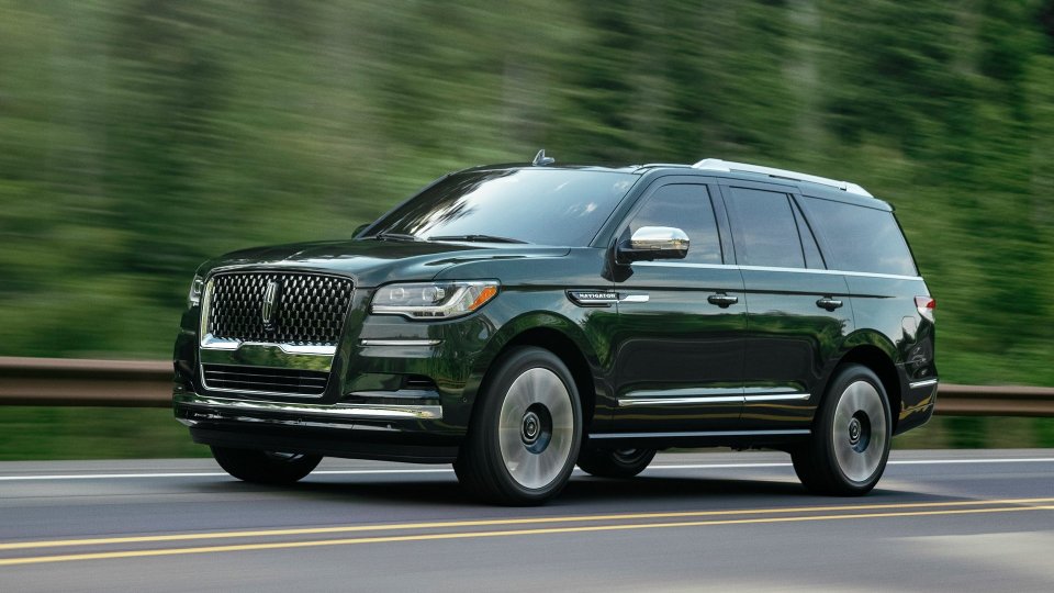 Dark green Lincoln Navigator driving on a road